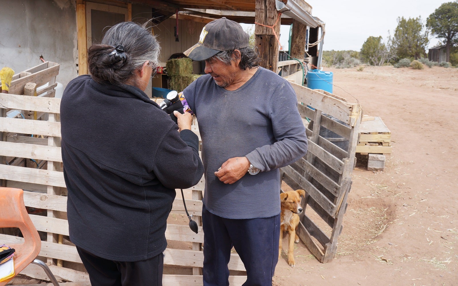 Community Health Representative takes blood pressure of man.